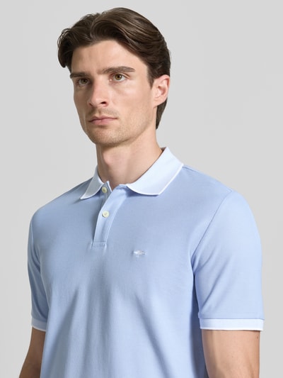 Männermodel trägt Modern Fit Poloshirt mit Stitching von Fynch-Hatton in lichtblauw, katoen, polokraag, knoopsluiting, borstlogo, Nahaufnahme Oberkörper.