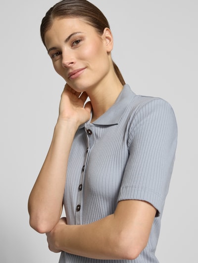 Vrouwenmodel draagt Slim Fit poloshirt uit katoen-modal-mix van Marc O'Polo, look: effen, korte mouw, ribtricot, labelstitching, polokraag, korte knoopsluiting, mix van katoen en modal. Nahaufnahme bovenlichaam.