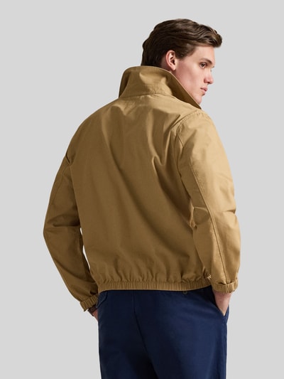 Männermodel trägt Regular Fit blouson van puur katoen van Polo Ralph Lauren, look: effen, platte kraag, ritssluiting, logodetail, lange mouw, elastische rompzoom en mouwboord, zij-steekzakken, kleur beige, ganzkörperansicht rückansicht.
