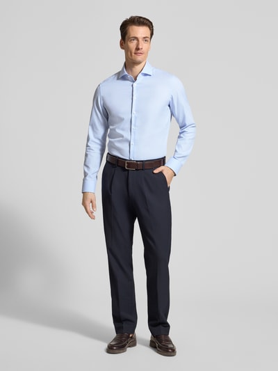 Mannenmodel draagt lichtblauw 'Slim Fit Business-Hemd aus Baumwolle mit Kentkragen' van SEIDENSTICKER, fijne structuur, voorkant volledige lichaam. Context: heren business-hemd van SEIDENSTICKER, pure katoen, slim fit, fijne structuur, kentkraag, knopenrij, ruglengte maat 40: 70 cm, schouderbreedte maat 40: 45 cm, mouwlengte maat 40: 65 cm.