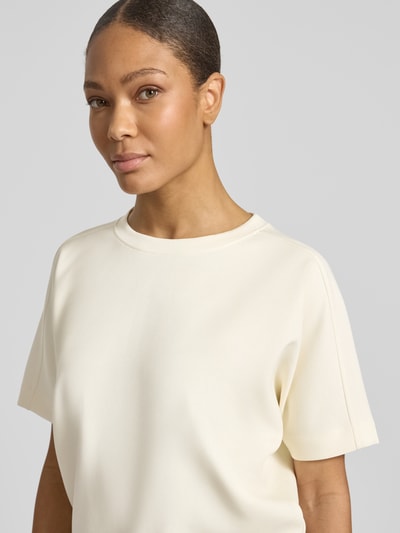 Frauenmodel trägt T-Shirt aus Modal-Mix mit Rundhalsausschnitt Modell 'Gosa' von OPUS in Creme, glatte Textur, Nahaufnahme Oberkörper.