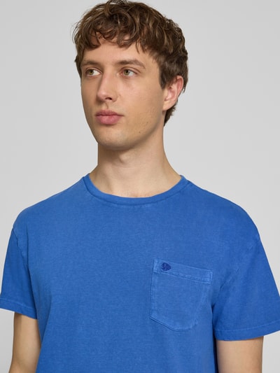Männermodel trägt T-Shirt aus Baumwoll-Leinen-Mix mit Brusttasche von Superdry in Blau, mit Rundhalsausschnitt, Regular-Fit, Nahaufnahme Oberkörper, Rückenlänge bei Größe M: 66 cm.