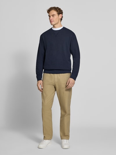 Mannelijk model draagt Regular Fit Sweatshirt aus Baumwoll-Mix van Scotch & Soda in donkerblauw katoenmix met ronde hals, elastische boordjes, heren sweatshirt, ruglengte maat M 61 cm, mouwlengte maat M 70 cm, geheel van voren.