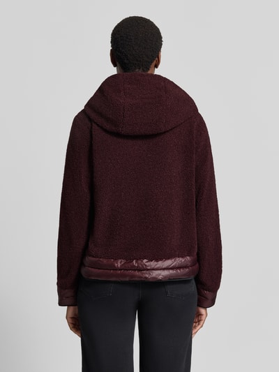 Modelka nosi Regular Fit Jacke mit Kapuze von FUCHS SCHMITT, Futerko, krój regular fit, kaptur, zamek błyskawiczny dwustronny, Długość tyłu w rozmiarze 36: 57 cm, Szerokość ramion w rozmiarze 36: 41 cm, Szerokość klatki piersiowej w rozmiarze 36: 48 cm, Długość rękawów w rozmiarze 36: 62 cm, kolor bordowy, prosty fason, tekstura futerka, widok całej sylwetki od tyłu.