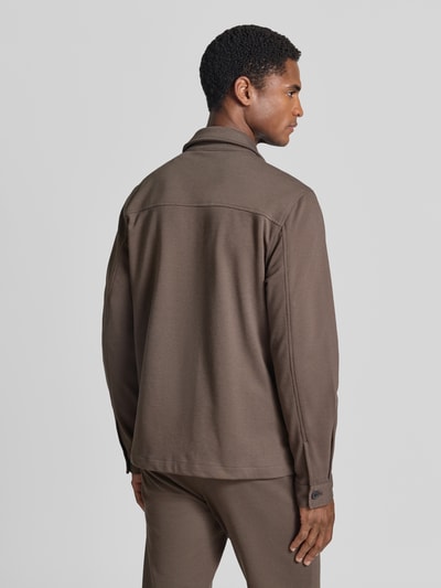 Männermodel trägt Slim Fit Hemdjacke mit Viskose-Anteil von Lindbergh in Braun, glatte Struktur, Rückenansicht, Ganzkörperansicht Rückansicht. Elastischer Material-Mix, Umlegekragen, durchgehende Knopfleiste, Brusttasche, Eingrifftaschen, Rückenlänge bei Größe M: 70 cm.