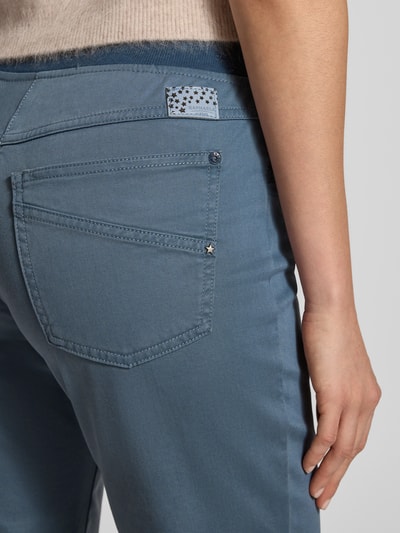 Frauenmodel trägt Flared Fit Stoffhose aus Lyocell-Mix Modell 'Pamina' von Raphaela By Brax mit Gesäßtaschen, Detailaufnahme. Elastischer Lyocell-Mix mit Baumwoll-Anteil im Flared Fit, Bundweite bei Größe 36: 37 cm, Innenbeinlänge bei Größe 36: 80 cm.