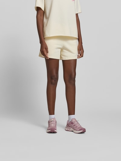 Frauenmodel trägt Shorts mit Modal-Anteil von Juvia aus Baumwoll-Mix, Regular-Fit mit Eingrifftaschen, elastischem Bund und Tunnelzug, Ganzkörperansicht von vorne.