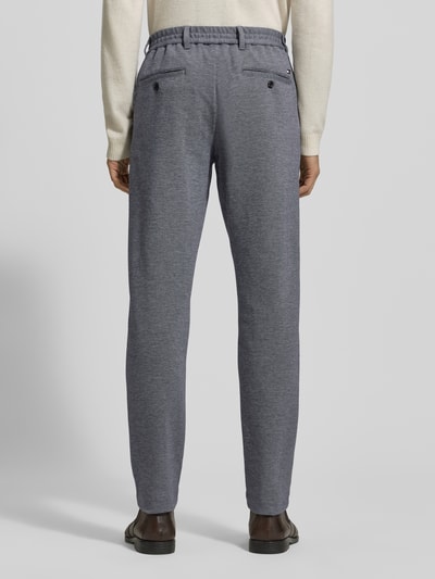 Männermodel trägt Relaxed Fit Schmale Hose aus reiner Baumwolle Modell 'HARLEM' van Tommy Hilfiger, unifarben two tone, label stitching, elastische taille, steekzakken, grijze stof met fijne textuur, Ganzkörperansicht Rückansicht.