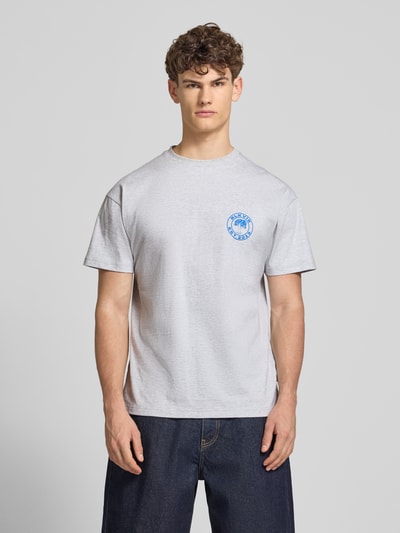 Mannelijk model draagt T-Shirt mit Logo und Rundhalsausschnitt van BLKVIS in lichtgrijs, regular fit, puur katoen, logo links op de borst, ruglengte maat M 70 cm, vooraanzicht busteshot.