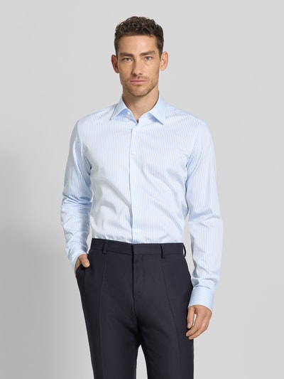 Männermodel trägt Regular Fit Businesshemd mit extra langem Arm Modell 'H-JOE-K' von BOSS, gestreift, Kentkragen, Ganzkörperansicht von vorne.