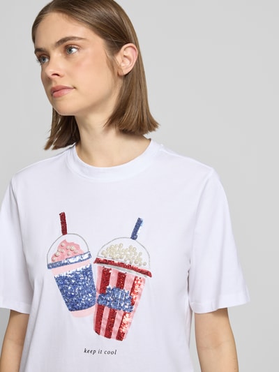 Frauenmodel trägt Regular Fit T-Shirt aus reiner Bio-Baumwolle Modell 'BURST' von Only, Optik: Unifarben, Applikation: Perlen- und Paillettenbesatz auf der Vorderseite, Materialverarbeitung: Jersey, Rundhals, Kurzarm, Nahaufnahme Oberkörper.