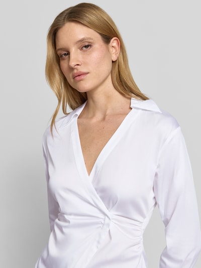 Frauenmodel trägt Bluse mit Raffungen und V-Ausschnitt von comma, weiß, taillierter Schnitt, Baumwoll-Mix, Nahaufnahme Oberkörper.