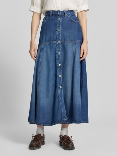 Frauenmodel trägt Maxirock aus Lyocell-Mix in Denim-Optik Modell 'Nidia' von Guess, leicht ausgestellt, 5-Pocket-Design, Ganzkörperansicht von vorne.