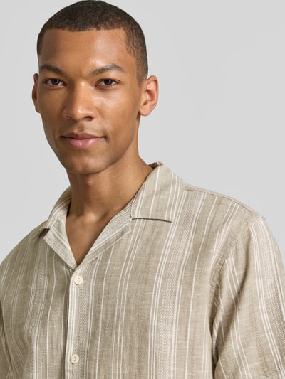 Männermodel trägt Regular Fit Freizeithemd mit Leinen-Anteil Modell 'Summer' von Jack & Jones Premium, Nahaufnahme Oberkörper, Baumwoll-Mix mit Leinen-Anteil, Reverskragen, Kurzärmelig, durchgehende Knopfleiste, natürliche Beige- und Cremetöne, feine Streifen, strukturierte Oberfläche.