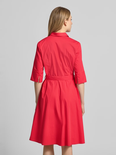 Modelka nosi Knielanges Hemdblusenkleid mit Bindegürtel od Christian Berg Woman Selection, bawełniany miks ze stretchem, długość do kolan, ukryta listwa guzikowa, pasek, szerokość w rozmiarze 36: 48 cm, długość tyłu: 99 cm, długość rękawa: 37 cm, widok całej sylwetki z tyłu.