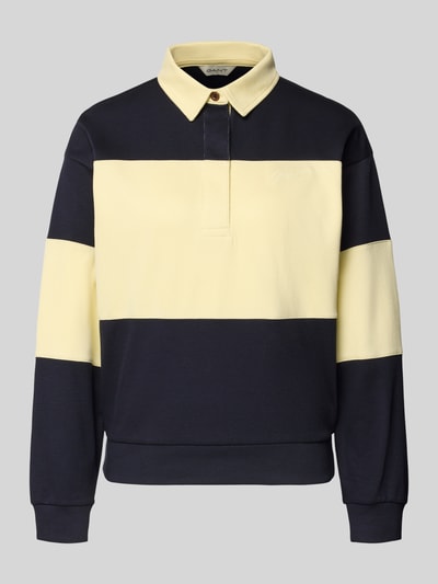 Produktfoto, Sweatshirt mit Polokragen und Label-Stitching von Gant, bawełna, krój relaxed fit, wyhaftowane logo, kołnierzyk polo, listwa guzikowa, żółto-granatowe szerokie pasy, gładka tekstura.