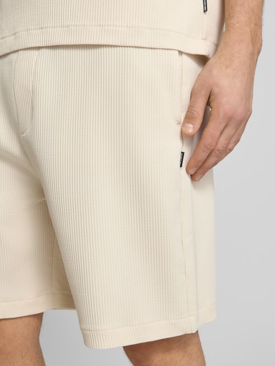 Männermodel trägt Shorts in Plissee-Optik mit elastischem Bund von REVIEW, Material-Mix mit Stretch-Anteil, Regular-Fit, Nahaufnahme Oberschenkel.