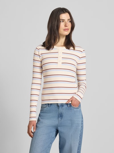 Frauenmodel trägt Slim Fit Langarmshirt aus Baumwoll-Mix Modell 'KATIE' von Vero Moda, mehrfarbig gestreifte Optik, Feinstrick, Rundhals-Ausschnitt, kurze Knopfleiste, Ganzkörperansicht von vorne.