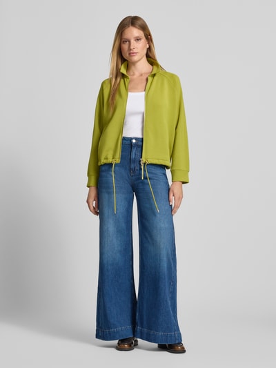 Kobiece modelka nosi Wide Leg Jeans mit Label-Detail Modell 'Eila' od JOOP!, niebieski denim, bawełna, wpuszczane kieszenie, szerokość w rozmiarze 27: 38 cm, długość wewnętrzna nogawki w rozmiarze 27: 80 cm, widok całej sylwetki z przodu.