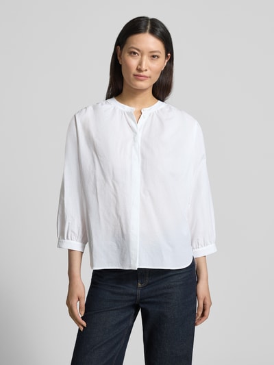Frauenmodel trägt Bluse mit verdeckter Knopfleiste und verlängertem Rücken von Luisa Cerano in Weiß, reine Baumwolle, lockere Passform, Rundhalsausschnitt, Ganzkörperansicht von vorne.