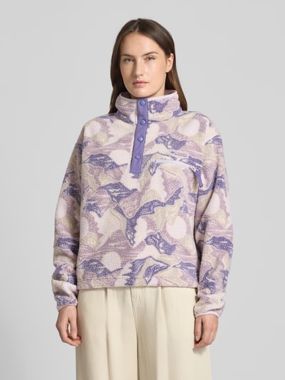 Modelka kobieca nosi Regular Fit Pullover mit Logo-Patch Modell 'Helvetia' od COLUMBIA w kolorach fioletu, beżu i kremu, faktura polaru, elastyczne mankiety, kieszonka na piersi z zamkiem, stójka, guziki, kontekst: Bluza damska, długość pleców 55 cm, szerokość ramion 44 cm, szerokość w rozmiarze S 58 cm, długość rękawa 58 cm, widok całej sylwetki z przodu.