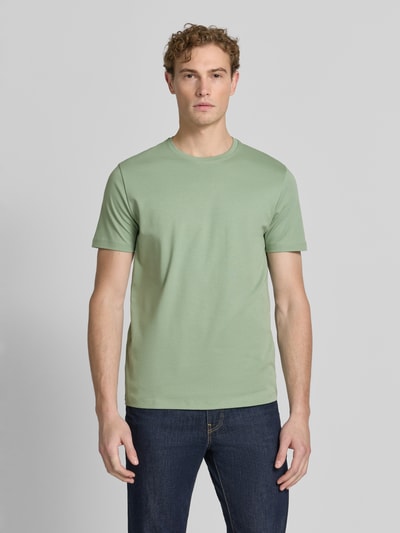 Męski model nosi T-Shirt aus Baumwolle mit Rundhalsausschnitt von Christian Berg Men w kolorze zielonym, krój regular fit, długość tyłu w rozmiarze M: 35 cm, bawełna, okrągły dekolt, widok całej sylwetki z przodu.