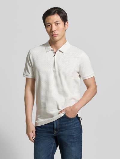 Męski model nosi Regular Fit Poloshirt mit kurzem Reißverschluss von Lerros z bawełny, fakturowany wzór, kołnierzyk polo, wyhaftowane logo, naszywka z logo, długość tyłu w rozmiarze M: 72 cm, jasny kolor, prosty fason, całkowity widok z przodu.