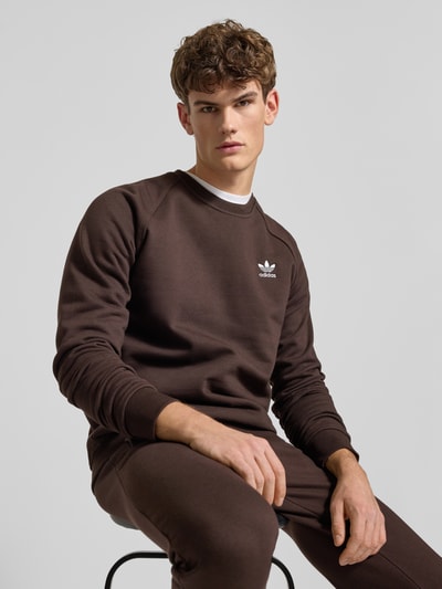 Männermodel trägt Sweatshirt mit Label-Stitching von adidas Originals aus Baumwoll-Elasthan-Mix, lockerer Schnitt, Nahaufnahme Oberkörper.