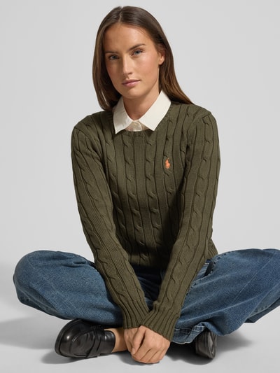 Frauenmodel trägt Strickpullover mit Zopfmuster Modell 'JULIANNA' von Polo Ralph Lauren in olivgrün, Reine Baumwolle, Slim Fit, Label-Stitching, Rundhalsausschnitt, Nahaufnahme Oberkörper.