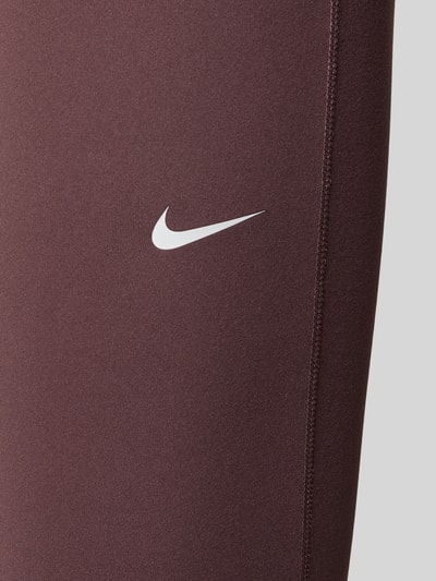 Produktfoto, Flared Leggings mit Logo von NIKE TRAINING in Dunkelbraun mit weißem Logo, glatte Textur, Material-Mix mit Stretch-Anteil, elastischer Bund