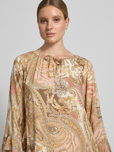 Frauenmodel trägt Regular Fit Bluse aus Viskose mit Paisley-Muster von monari, Allover-Look, Rundhalsausschnitt mit Schnürung, Nahaufnahme Oberkörper.