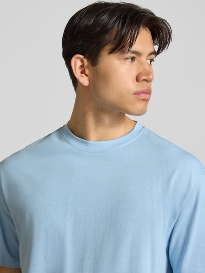 Männermodel trägt Oversized T-Shirt Modell 'FISHER' von Blend in Hellblau aus Reine Baumwolle, Nahaufnahme Oberkörper. Herren T-Shirt, Rundhalsausschnitt, Rückenlänge bei Größe M: 72 cm.