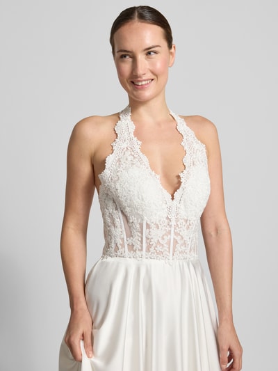 Kobiece modelka nosi Brautkleid mit floralem Stitching od Mascara, fason taliowany, dekolt w serek, wiązanie na szyi, wyhaftowany kwiatowy wzór, szerokość w rozmiarze 36: 39 cm, długość tyłu w rozmiarze 36: 129 cm, zbliżenie na górną część ciała