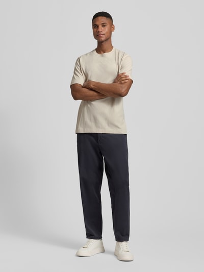 Männermodel trägt Regular Fit T-Shirt aus reiner Baumwolle von Marc O'Polo in Beige, unifarben, Jersey, Rundhals, Ganzkörperansicht von vorne.