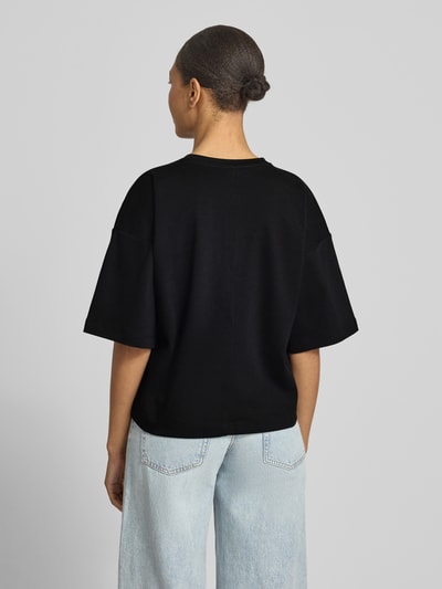 Frauenmodel trägt Oversized T-Shirt aus reiner Baumwolle von s.Oliver RED LABEL, unifarben, kurzarm, Jersey, Ganzkörperansicht Rückansicht.