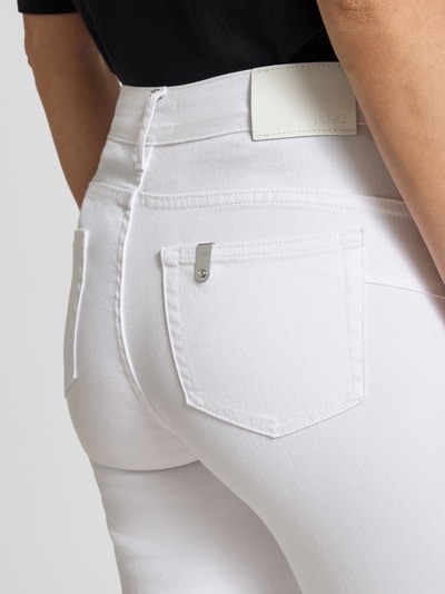 Frauenmodel trägt Flared Jeans mit Knopfleiste Modell 'PRINCESS' von Liu Jo White aus Baumwoll-Mix mit Stretch-Anteil, Detailaufnahme.