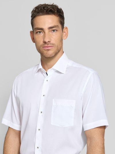 Männermodel trägt Regular Fit Freizeithemd aus Lyocell-Mix von ETERNA, weiß, Kurzarm, Kentkragen, Brusttasche, Nahaufnahme Oberkörper.