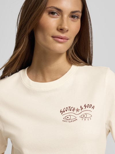 Vrouwenmodel draagt T-shirt met Label-Print en Rundhalsausschnitt van Scotch & Soda, beige, bio katoen, regular fit, Nahaufnahme bovenlichaam.