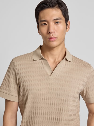 Mężczyznamodel nosi Koszulkę polo z prążkowanymi wykończeniami Model 'Cleison' od JOOP! Collection, bawełna, krój regular fit, dekolt w serek, beżowa faktura, detal: prążkowana struktura tkaniny, zbliżenie na górną część ciała.