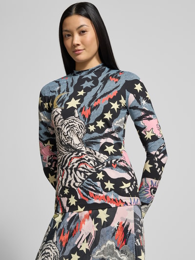 Kobiece modelka nosi bluzkę z długim rękawem Longsleeve im Allover-Look od Marc Cain, mieszanka materiałów z dodatkiem streczu, krój slim fit, wzór na całej powierzchni, stójka, długość tyłu 57 cm dla rozmiaru 36, kolorowa grafika z gwiazdami i tygrysem, widok całej sylwetki z przodu.