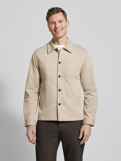 Männermodel trägt Relaxed Fit Hemdjacke mit Brusttasche von Lindbergh in Beige, Material-Mix, Umlegekragen, Knopfleiste, Ganzkörperansicht von vorne.