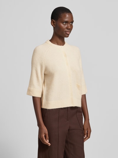 Frauenmodel trägt Cardigan mit Eingrifftasche Modell 'Dathena' von OPUS in Creme, Material-Mix mit Mohair, gerader Schnitt, Nahaufnahme Oberkörper.