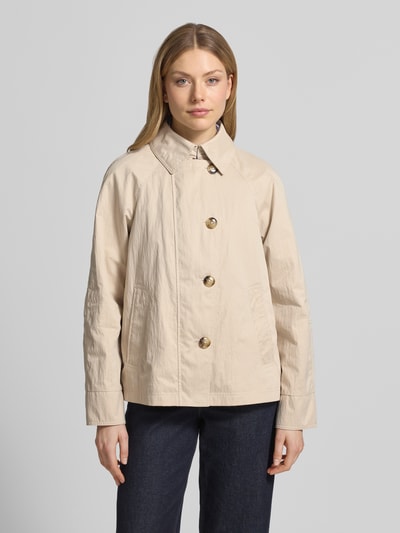 Vrouwenmodel draagt Jacke mit seitlichen Eingrifftaschen und Kentkragen van Fuchs Schmitt in beige, recht model, knoopsluiting, raglanmouwen, steekzakken, kentkraag, ruglengte maat 36: 64 cm, schouderbreedte maat 36: 38 cm, borstwijdte maat 36: 51 cm, mouwlengte maat 36: 44 cm, voorkant volledig zichtbaar, Ganzkörperansicht von vorne.