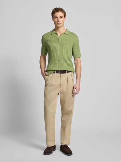Männermodel trägt Slim Fit Kurzarm Pullover mit Kaschmir-Anteil in Strick-Optik von FTC-Cashmere, hellgrün, Ganzkörperansicht von vorne.