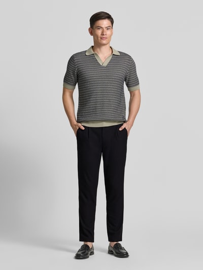 Männermodel trägt Slim Fit Stoffhose mit Viskose-Anteil von Lindbergh in Schwarz mit Strukturmuster, Bundfalten, Ganzkörperansicht von vorne.