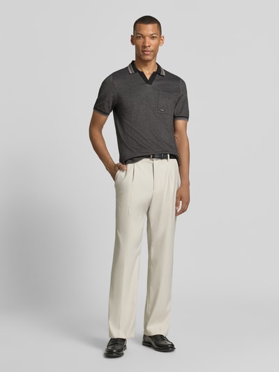 Männermodel trägt Regular Fit Poloshirt aus reiner Baumwolle Modell 'OPEN COLLAR POLO' von s.Oliver RED LABEL in melierter Optik, Piqué-Struktur, kurzarm, Polokragen, V-Ausschnitt, Label Stitching, Brusttasche, cremefarbene Hose, Ganzkörperansicht von vorne.