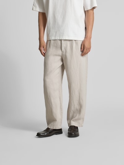 Männermodel trägt Straight Fit Leinenhose von Closed in Beige mit elastischem Bund und Eingrifftaschen, Nahaufnahme Unterkörper.