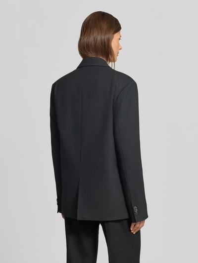 Frauenmodel trägt schwarzen Relaxed Fit Blazer mit Viskose-Anteil von MYON, glatte Textur, doppelte Knopfleiste, Rückansicht, Ganzkörperansicht.
