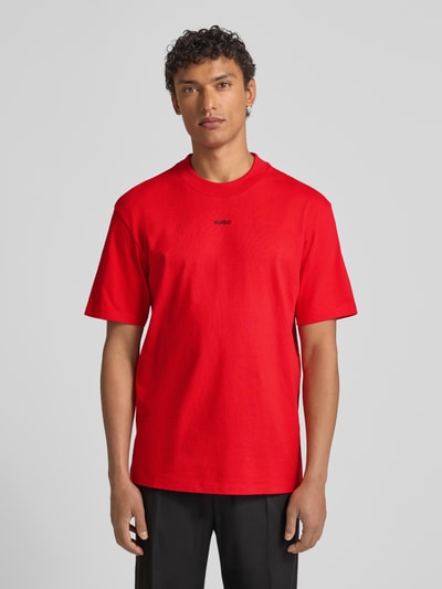 Männermodel trägt Relaxed Fit T-Shirt aus reiner Baumwolle Modell 'DAPOLINO' von HUGO, Optik: Unifarben, Label-Print, Ganzkörperansicht von vorne.
