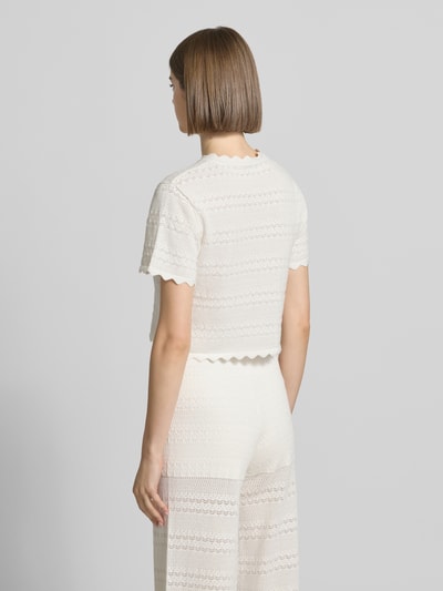 Frauenmodel trägt Damen T-Shirt in Strick-Optik Modell 'Serin' von OH APRIL aus Baumwoll-Viskose-Mix, Muschelsaum, Rückenlänge 42 cm, Gerader-Schnitt, Rückansicht Ganzkörperansicht.